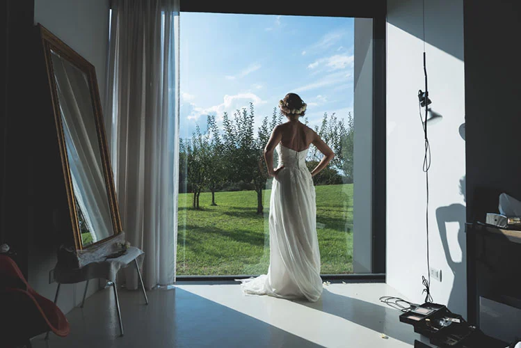 Sposa alla finestra con vista sul giardino