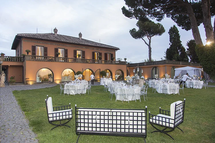 Prato di una villa allestito con tavoli e salotti per il ricevimento