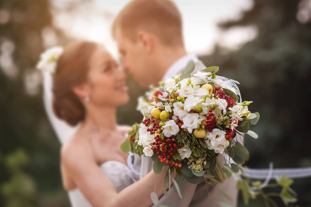 Sposi abbracciati con il bouquet di fiori