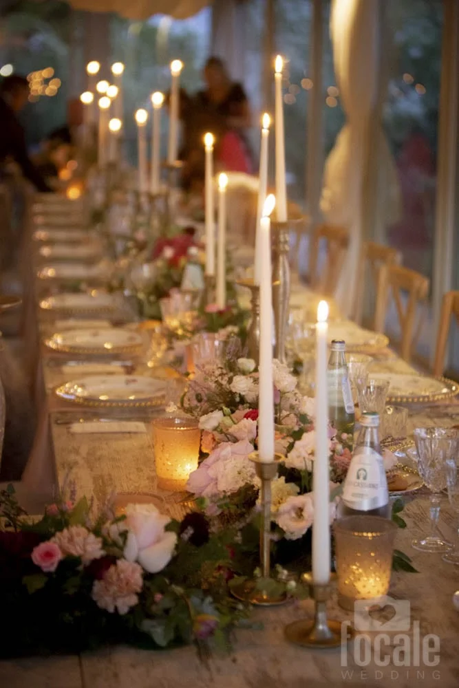 Tavolata con candele e fiori rosa al Castello di Montignano