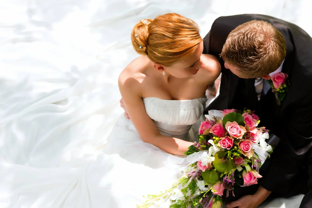 Sposi che si baciano con il bouquet