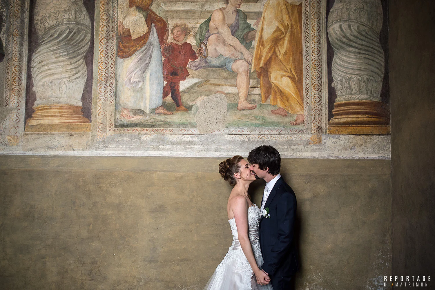 Bacio degli sposi davanti a un affresco antico